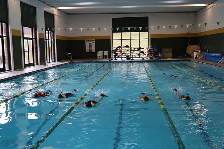 Piscina coberta do O.C. Skinner Natatorium com alunos treinando