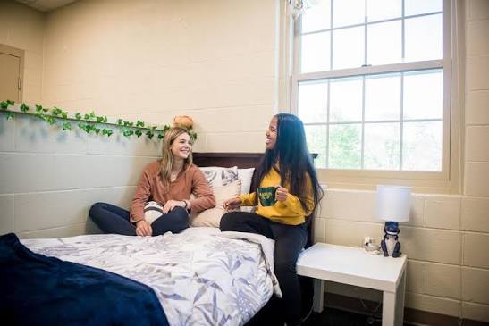 Duas estudantes conversando em um quarto de dormitório